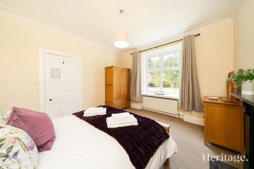 a bedroom with a bed with towels on it at Station Cottage Dinnet, Aboyne in Aboyne