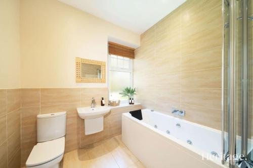 a bathroom with a toilet and a sink and a tub at Station Cottage Dinnet, Aboyne in Aboyne