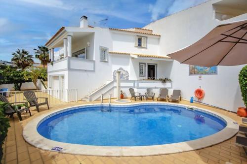 a villa with a swimming pool in front of a house at Vila Ventura Marina in Albufeira