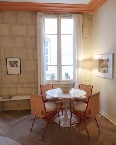 une table et des chaises dans une pièce avec une fenêtre dans l'établissement L'Arlésien, au cœur du centre historique, à Arles