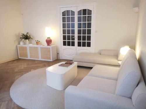 - un salon avec deux canapés blancs et une table dans l'établissement L'Arlésien, au cœur du centre historique, à Arles