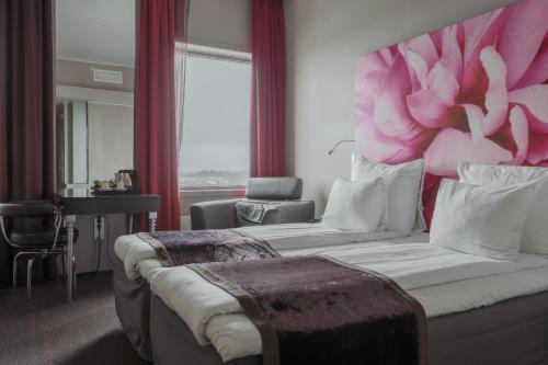 فندق كلاريون بيرغن إيربورت في بيرغِن: غرفة نوم مع سرير كبير مع اللوح الأمامي من زهرة وردية