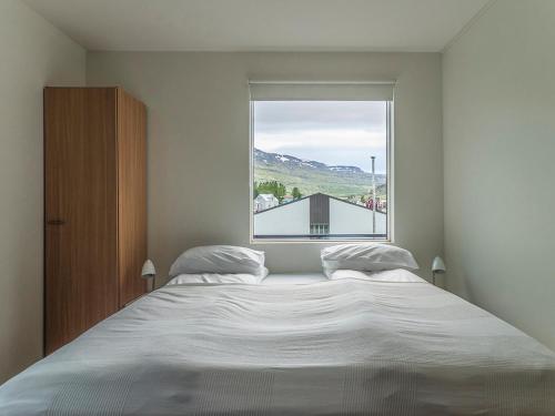 a bedroom with a large bed and a window at Seydisfjördur Guesthouse in Seyðisfjörður