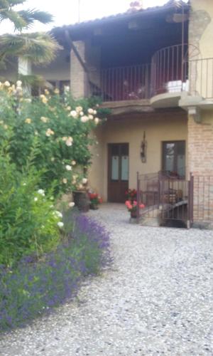 a house with a balcony and a yard with flowers at La Corte del Barbio in Aramengo