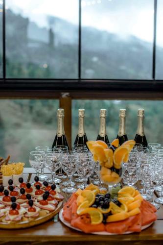 two pizzas and wine glasses on a table with wine bottles at Vaio Resort in Keda in Keda