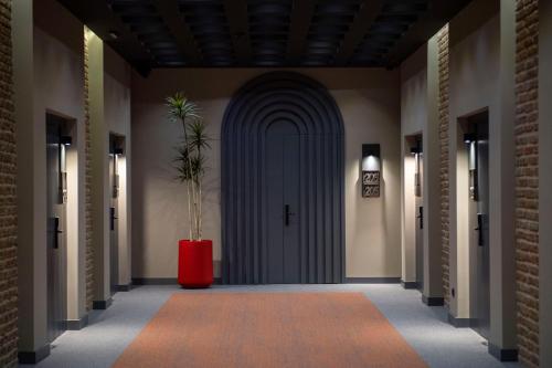 un corridoio con una porta blu e un vaso rosso di Qarvasla Hotel a Tbilisi City