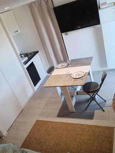 une cuisine avec une table et des chaises ainsi qu'une télévision dans l'établissement Studio dans le Vignoble Nantais, à Saint-Fiacre-sur-Maine