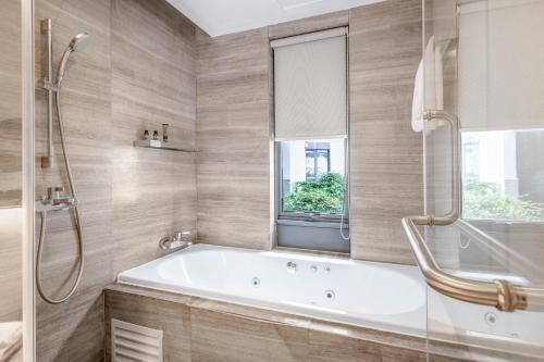 baño con bañera y ventana en CM Serviced Apartment Shenzhen Hillside, en Shenzhen