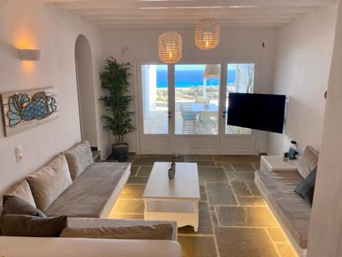 un soggiorno con divano e TV di Thalia Myconian Suites a Kalafatis