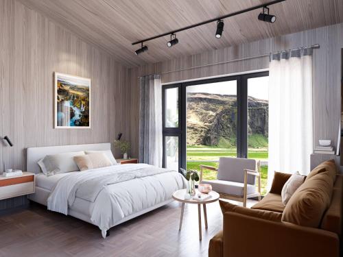 ハヴォルスヴォルールにあるSeljalandsfoss Horizonsのベッドルーム(大型ベッド1台付)、リビングルームが備わります。