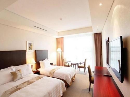 a hotel room with two beds and a table at Hotel Sunshine in Daejeon