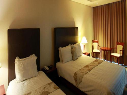 テジョンにあるHotel Sunshineのベッド2台、電話が備わるホテルルームです。