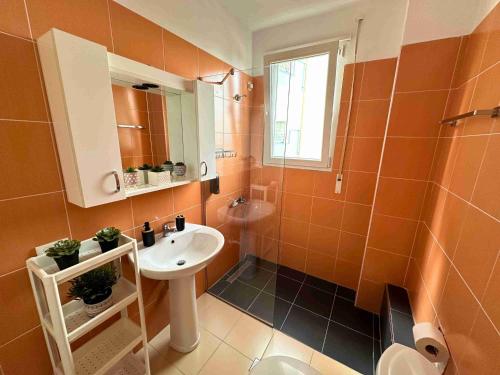 een badkamer met een wastafel, een toilet en een spiegel bij Tropicana Apartments in Dhërmi