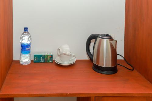 un hervidor de agua y una botella de agua en una mesa de madera. en Traveller's Hotel Hikkaduwa en Hikkaduwa