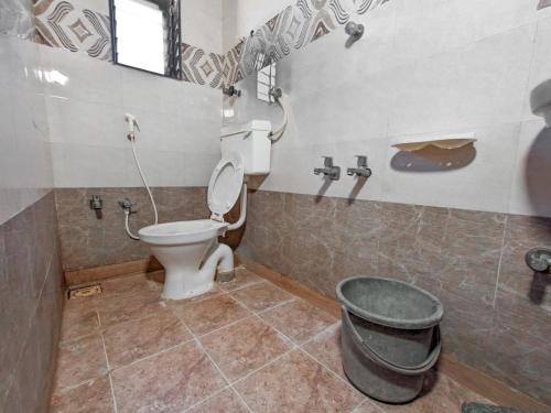 a bathroom with a toilet and a trash can at Maa Madhvadi Hotel & Restaurant in Mātānomadh