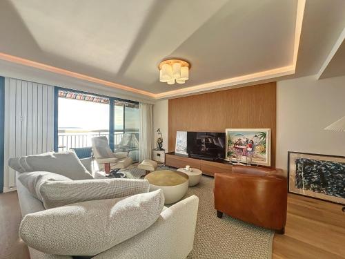 un salon avec des canapés et une télévision à écran plat dans l'établissement Neptunia, à Antibes