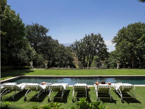 a group of people sitting in lawn chairs by a pool at Constantia Klein in Cape Town