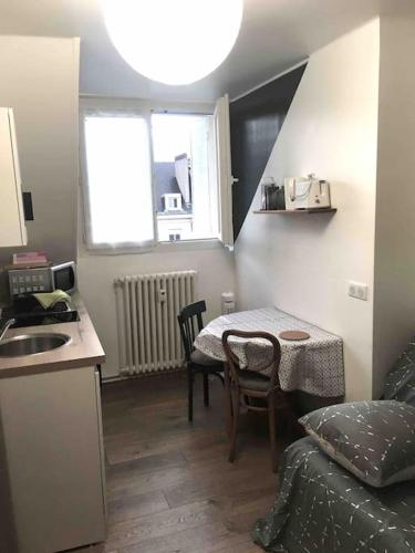 une petite cuisine avec une table et une salle à manger dans l'établissement Studio BATIK, à Chambéry