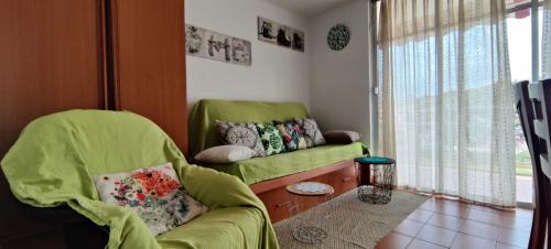 sala de estar con sofá verde y ventana en Reus y MAr Salou, en Salou
