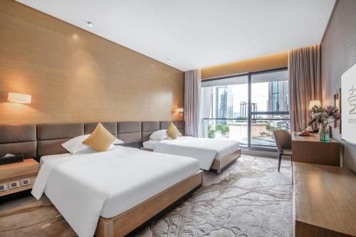 CM Serviced Apartment Shenzhen Hillside في شنجن: غرفة فندقية بسريرين ونافذة