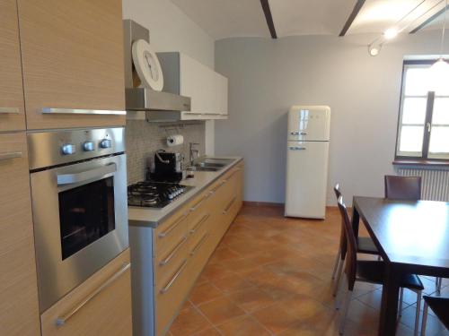 a kitchen with a stove and a refrigerator and a table at La Casa in Rivalta in Verduno