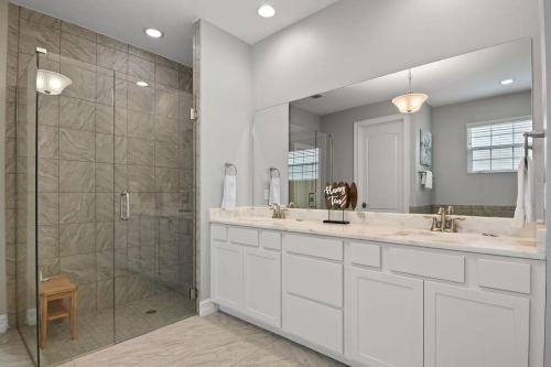 un bagno con due lavandini e una doccia di Fortebello Beachside 156 a Indian Harbour Beach