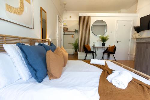 a bedroom with a bed with blue and white pillows at Brunswick - Brighton Regency Studio by the sea in Brighton & Hove