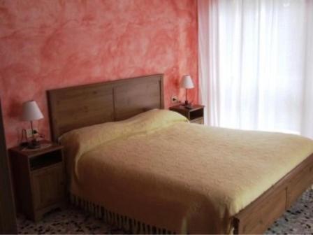 1 dormitorio con cama y pared roja en B&B Catullo, en Sirmione