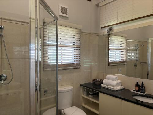 a bathroom with a shower and a toilet and a sink at The Block Vista B&B in Nanango