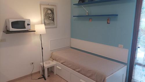 a small bedroom with a bed and a tv at Gli Oleandri in Capoliveri