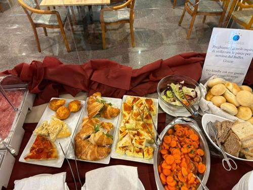 una tabella ricoperta da molti tipi di alimenti diversi di Hotel Maja a Pescara
