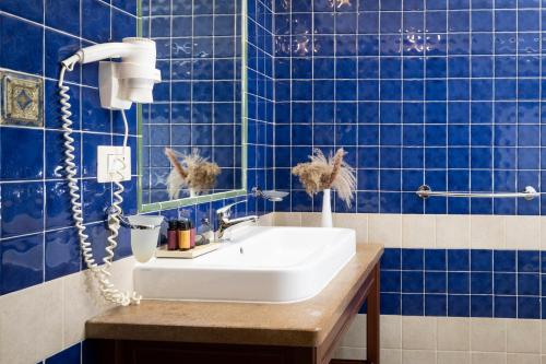 Baño de azulejos azules con lavabo y espejo en Badiula, en Carlentini