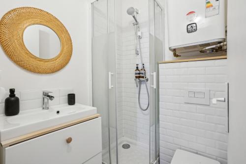 La salle de bains est pourvue d'une douche, d'un lavabo et d'un miroir. dans l'établissement Villa Arc de Triomphe, à Paris