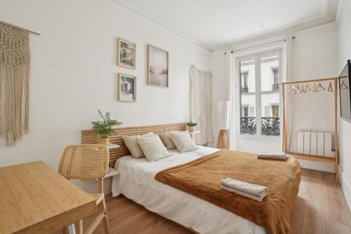 une chambre avec un grand lit et un bureau dans l'établissement Villa Arc de Triomphe, à Paris