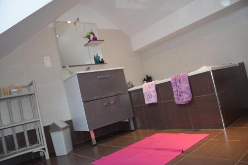 La salle de bains est pourvue d'un lavabo et d'un sèche-serviettes. dans l'établissement Hébergement Plage du Débarquement - 6/10 pers, à Sainte-Mère-Église