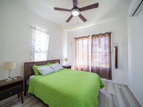 1 dormitorio con cama verde y ventilador de techo en Amazing 2br Villa Near Surfing Beaches, en Cabarete