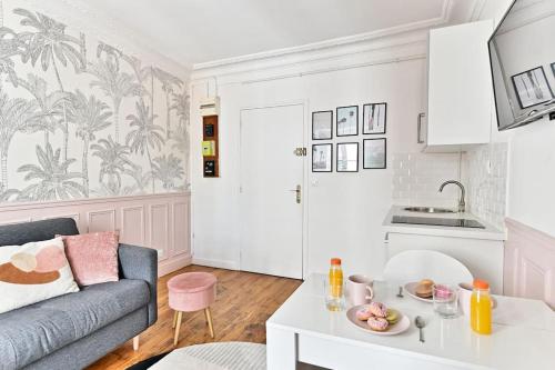 un salon avec un canapé et une table dans l'établissement Appartement proche Montparnasse - Rose, à Paris
