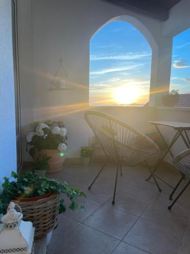 a balcony with a table and chairs and a sunset at Apartments BINGO in Cavtat