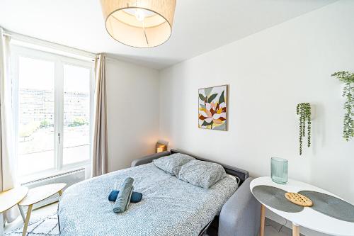 a bedroom with a bed and a table and chairs at Le Petit Clément - Charmant et Cosy in Villeurbanne