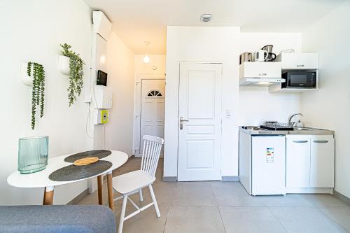 une petite cuisine avec une petite table, une petite table et des chaises dans l'établissement Le Petit Clément - Charmant et Cosy, à Villeurbanne