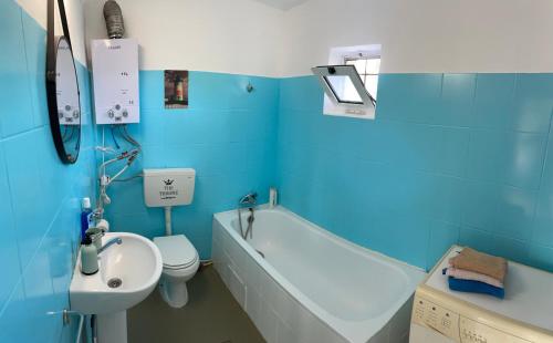 La salle de bains bleue est pourvue de toilettes, d'une baignoire et d'un lavabo. dans l'établissement Countryside Home, 