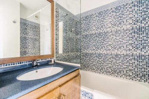 une salle de bain avec un lavabo, une baignoire et un miroir dans l'établissement Résidence le Hameau de Cap Esterel - maeva Home - Appartement 2 pièces 5 personnes - Confort MAE-9884, à Saint-Raphaël