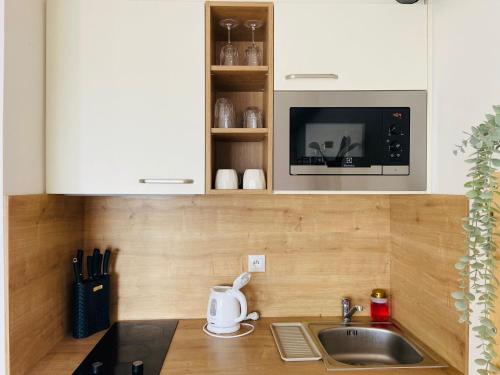 a kitchen with a sink and a microwave at Cozy studio on the roof, next to Incheba Expo in Bratislava