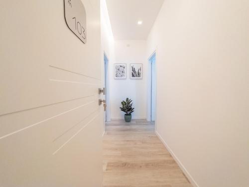 a hallway with white walls and wooden floors and a clock on the wall at White Ottaviano in Rome