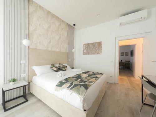 a white bedroom with a large bed and a desk at White Ottaviano in Rome