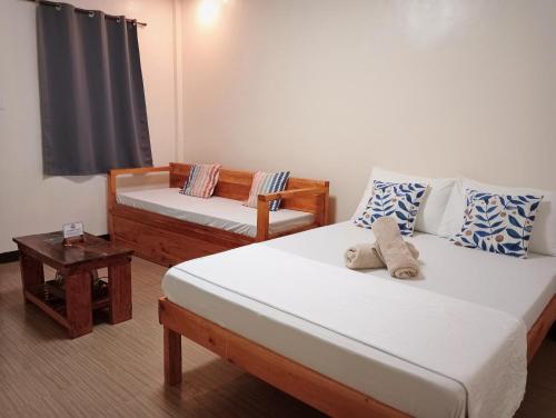 a small room with two beds and a table at Solana Siargao in Catagnan