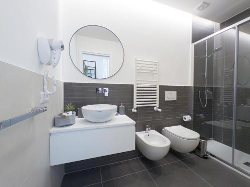 a bathroom with a sink and a toilet and a mirror at White Ottaviano in Rome