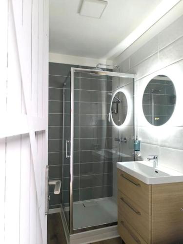 une salle de bain avec une douche en verre et un lavabo dans l'établissement NOUVEAU Les Grumes 2 - Maison - 2 chambres - Jardin - Neuf, à Compiègne