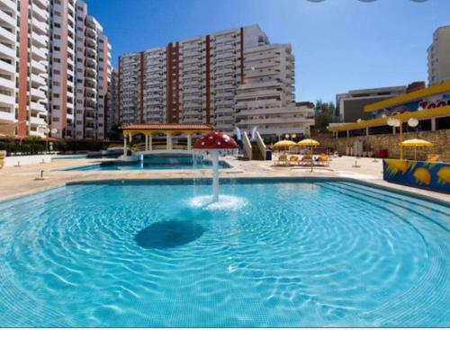 a large swimming pool with a fountain in a city at Casa3_Praia_Beach_House in Portimão