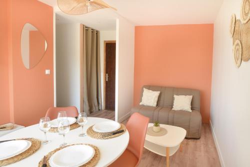 une salle à manger avec une table, des chaises et un canapé dans l'établissement Chez Flora - Appt pour 4 proche de la plage, à Saint-Aubin-sur-Mer